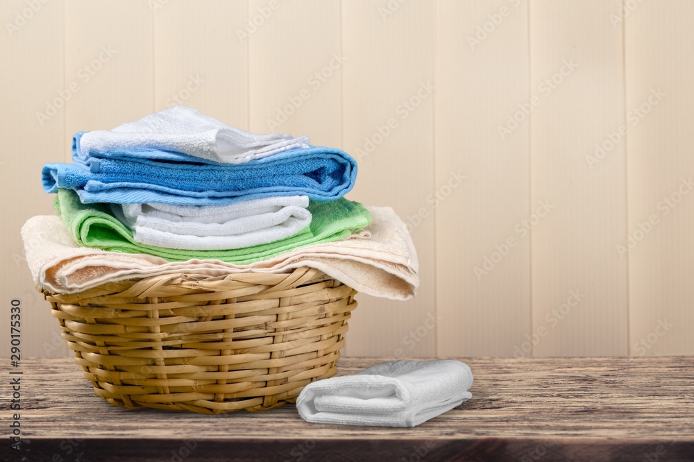 Laundry Basket with colorful towels on background