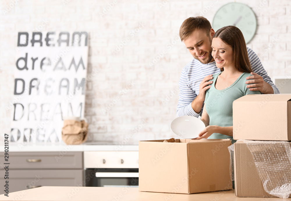 Young couple unpacking things after moving into new house