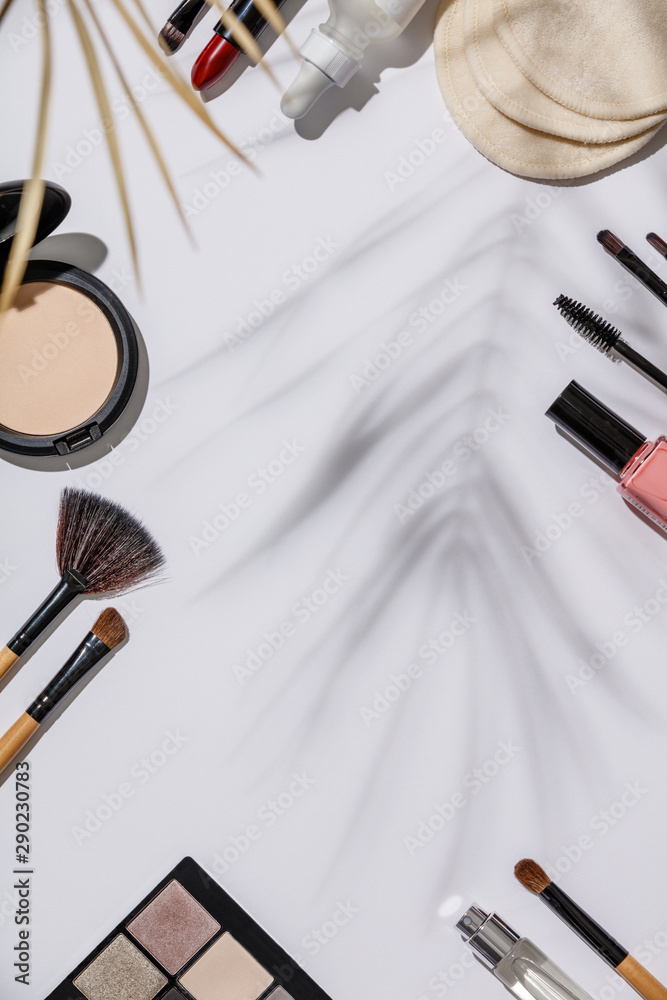 Makeup brushes and cosmetic products on a white background