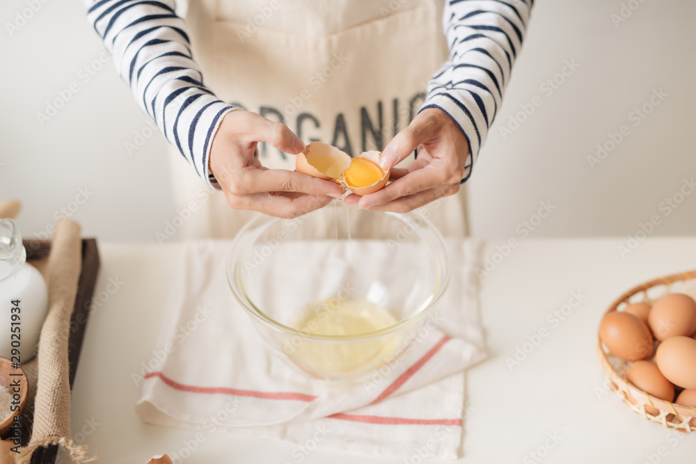 broken egg in hands with separated yolk closeup