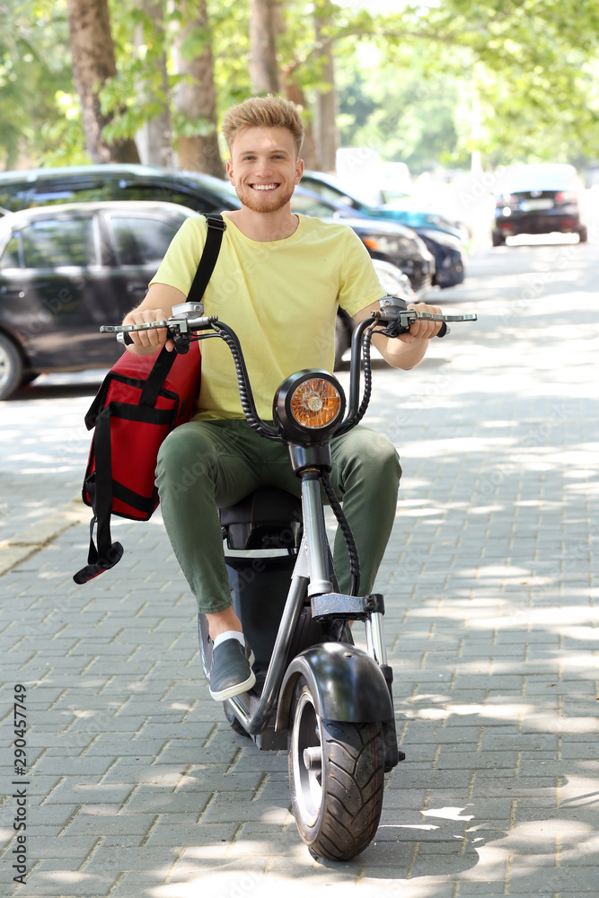 Worker of food delivery service driving scooter outdoors