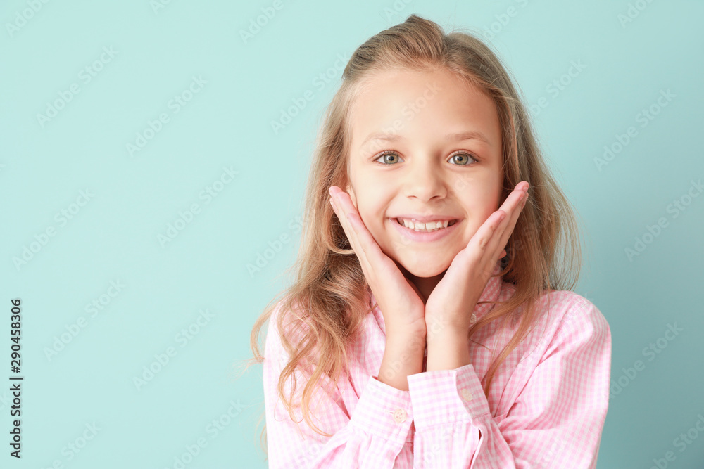 Portrait of happy little girl on color background