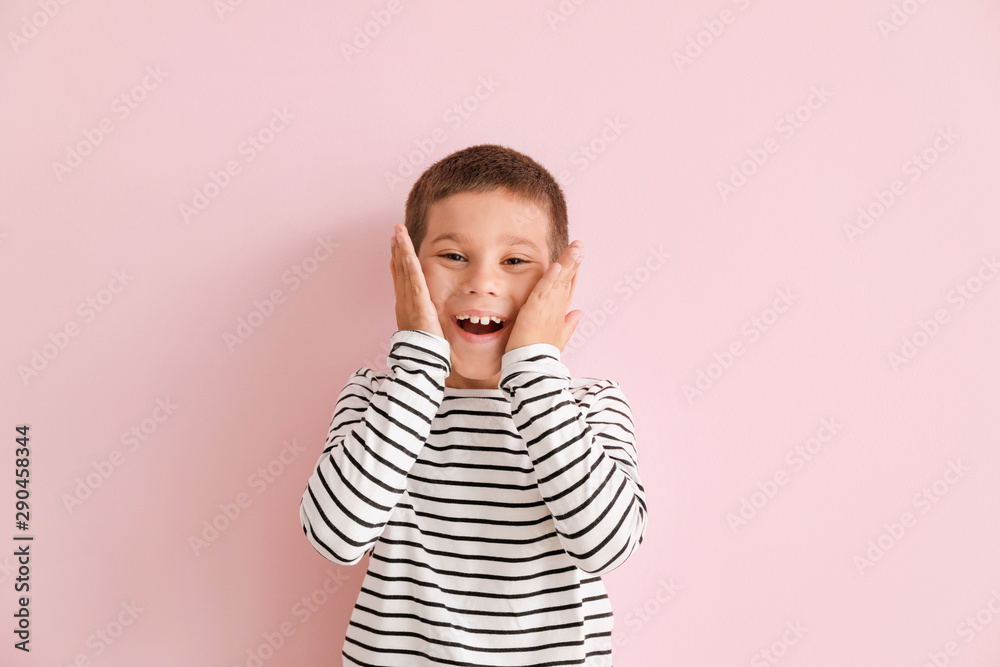 Portrait of happy little boy on color background