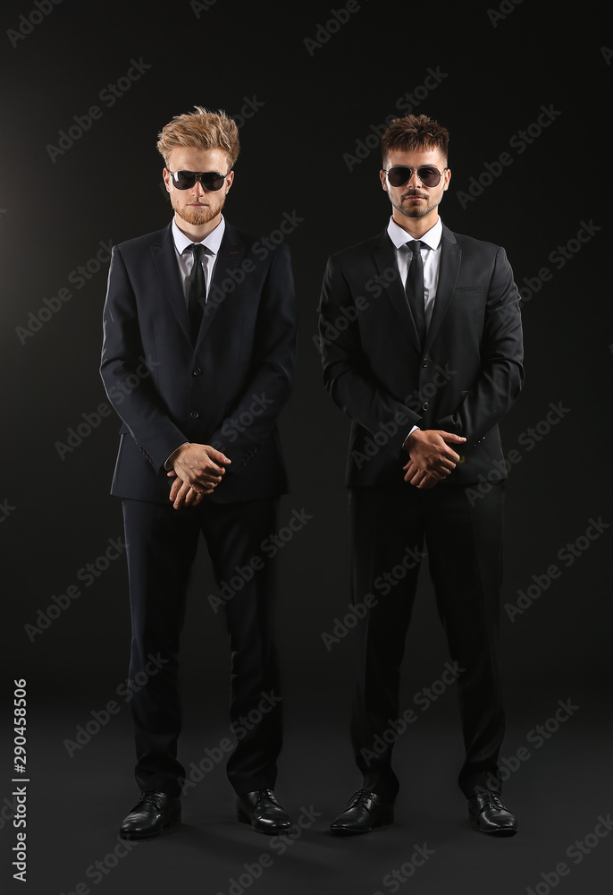 Handsome security guards on dark background