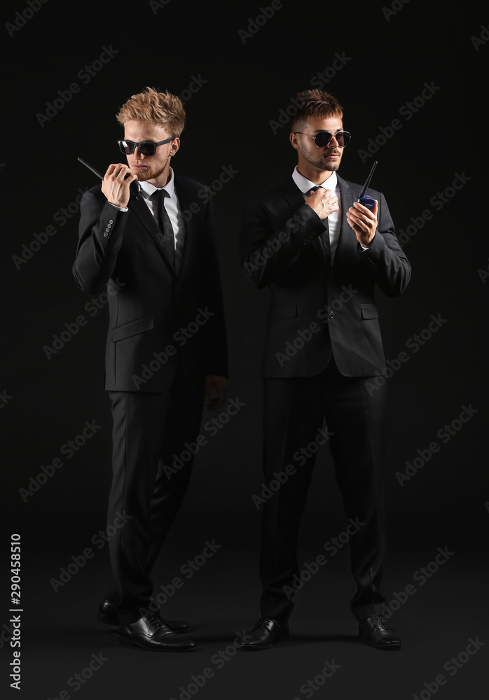 Handsome security guards on dark background