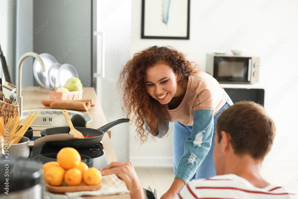 Happy couple cooking together in kitchen