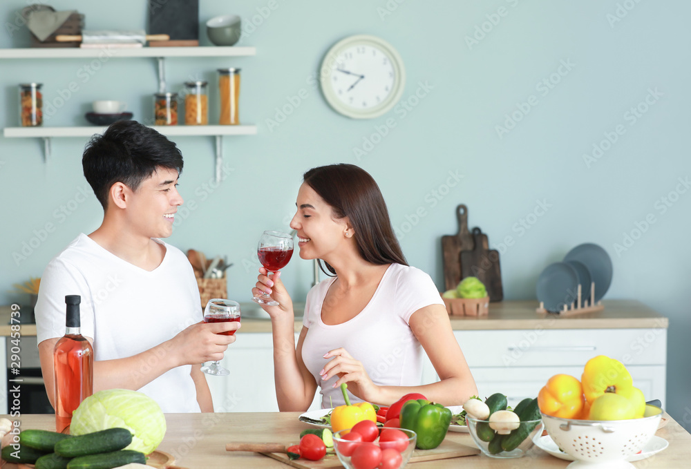 幸福夫妻在厨房做饭时喝酒