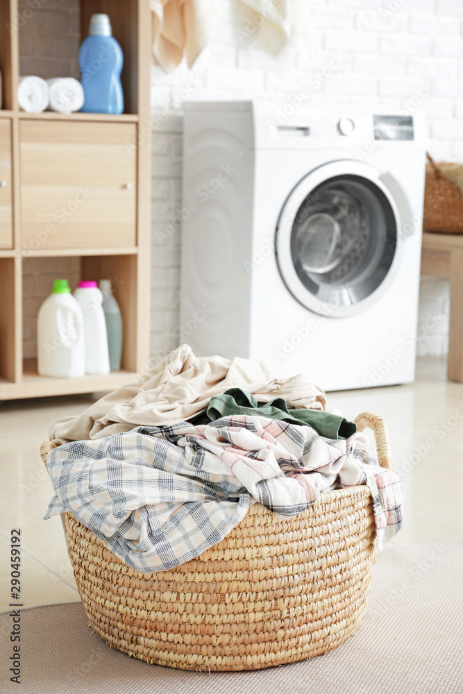 Basket with dirty laundry on floor in bathroom