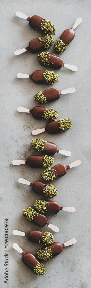 Ice cream popsicle pattern. Flat-lay of chocolate glazed ice cream pops with pistachio icing over gr