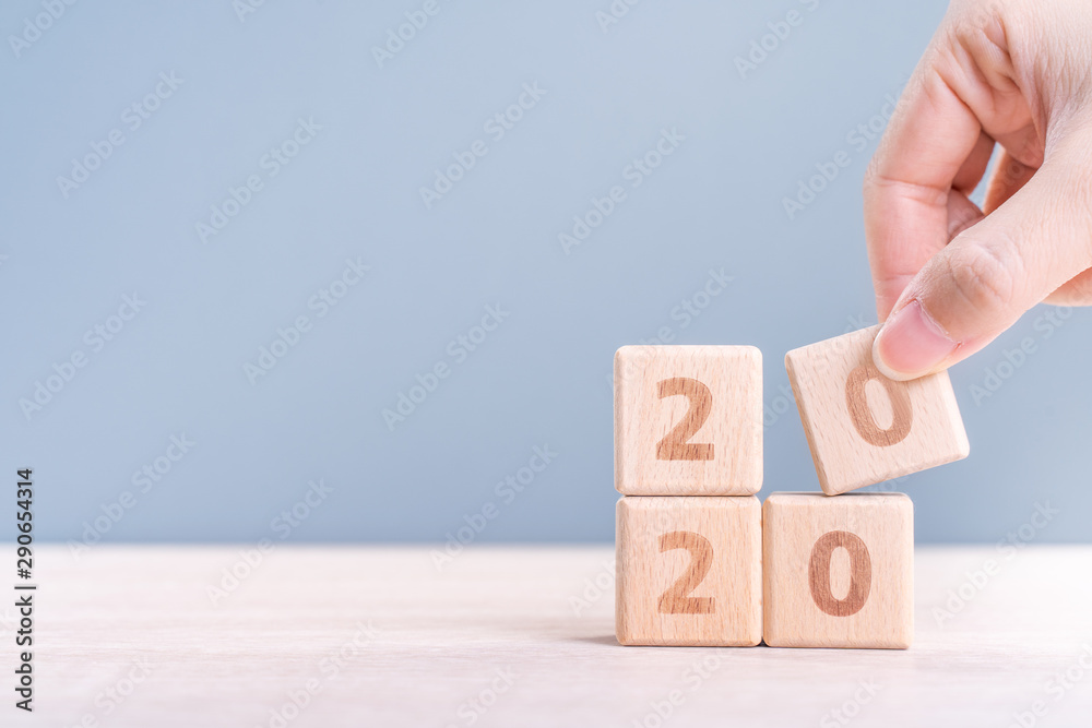 Abstract 2020 & 2019 New year countdown design concept - woman holding wood blocks cubes on wooden t