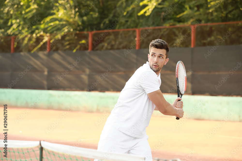 Young man playing tennis on court