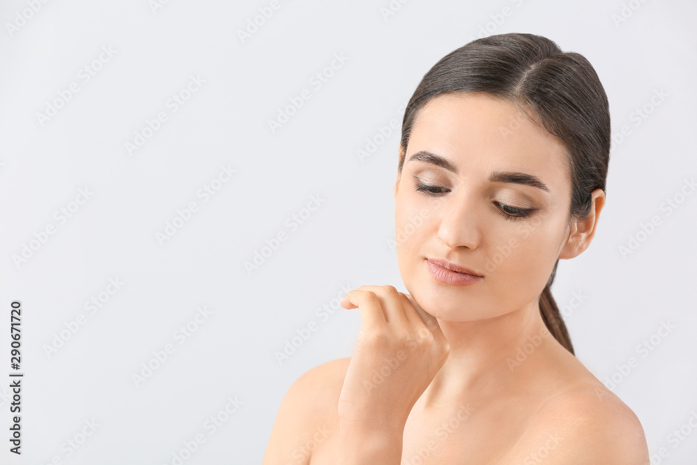 Young woman with beautiful eyebrows on light background