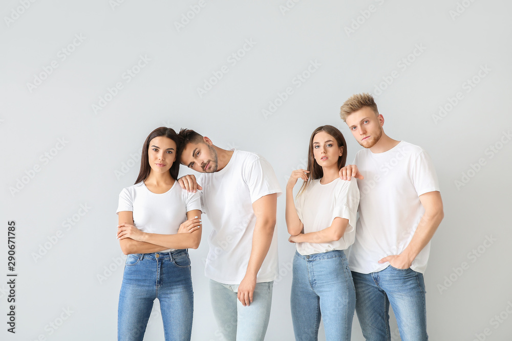 Group of young people in stylish casual clothes on light background