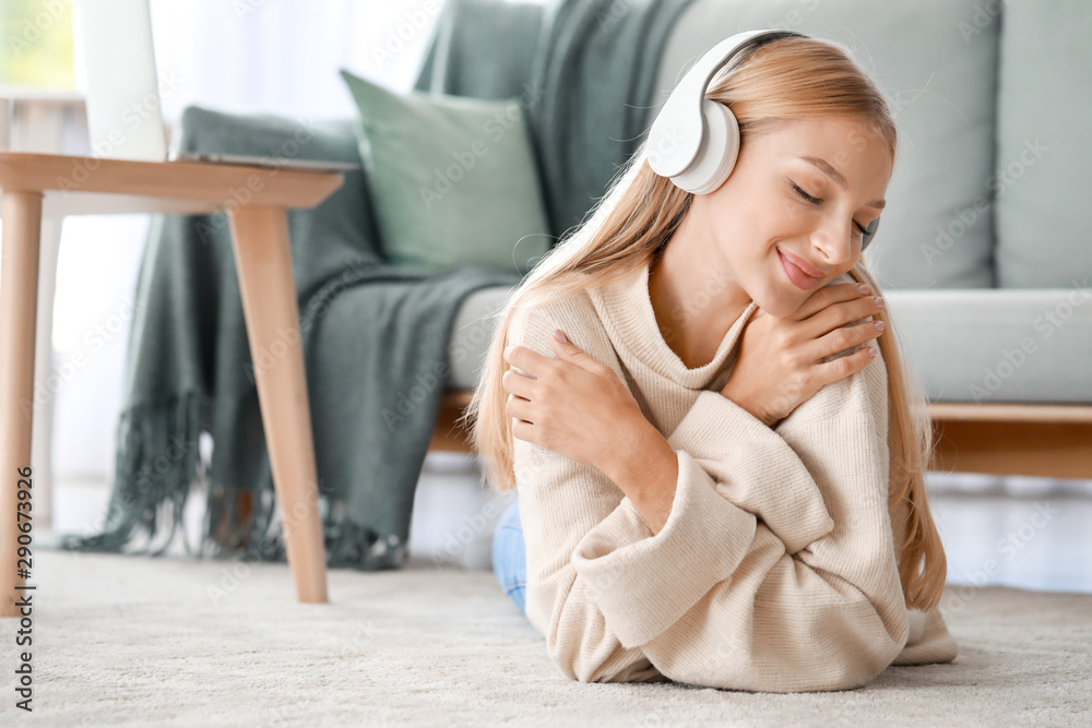 Beautiful young woman listening to music at home