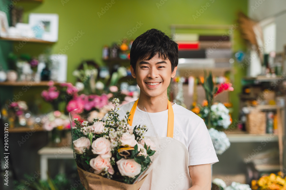 一位年轻快乐的亚洲男花店老板在店里工作