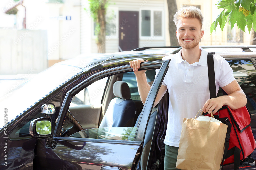 Worker of food delivery service near car outdoors