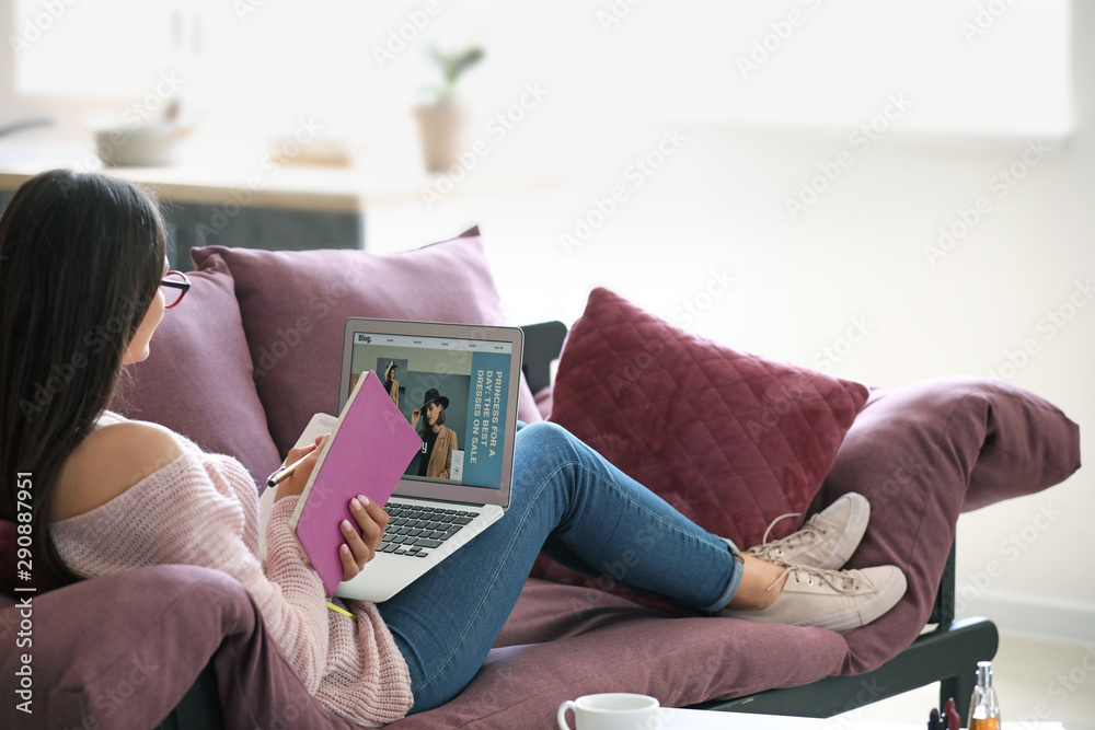 Young fashion blogger with laptop at home