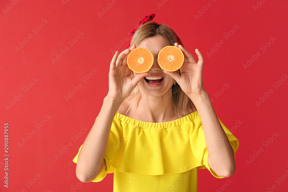 Happy beautiful woman with orange fruit on color background