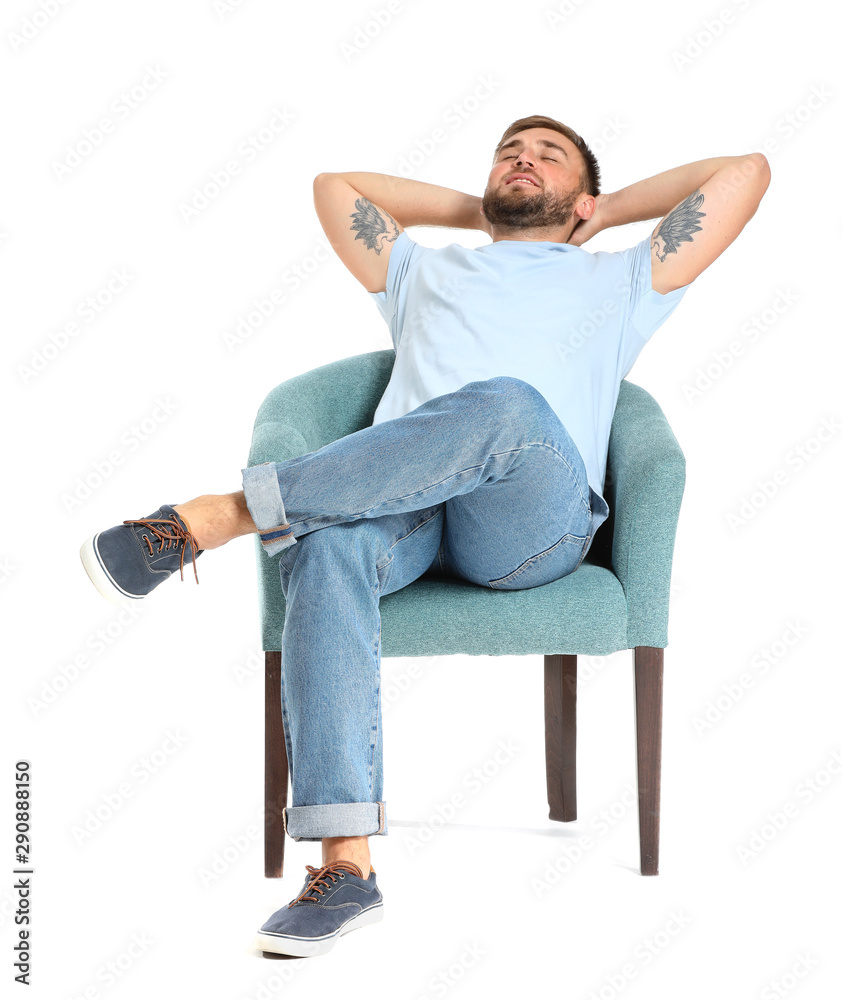 Handsome young man relaxing in armchair against white background