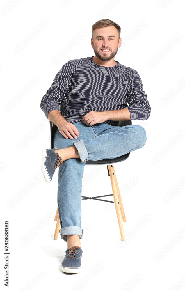 Handsome young man sitting on chair against white background