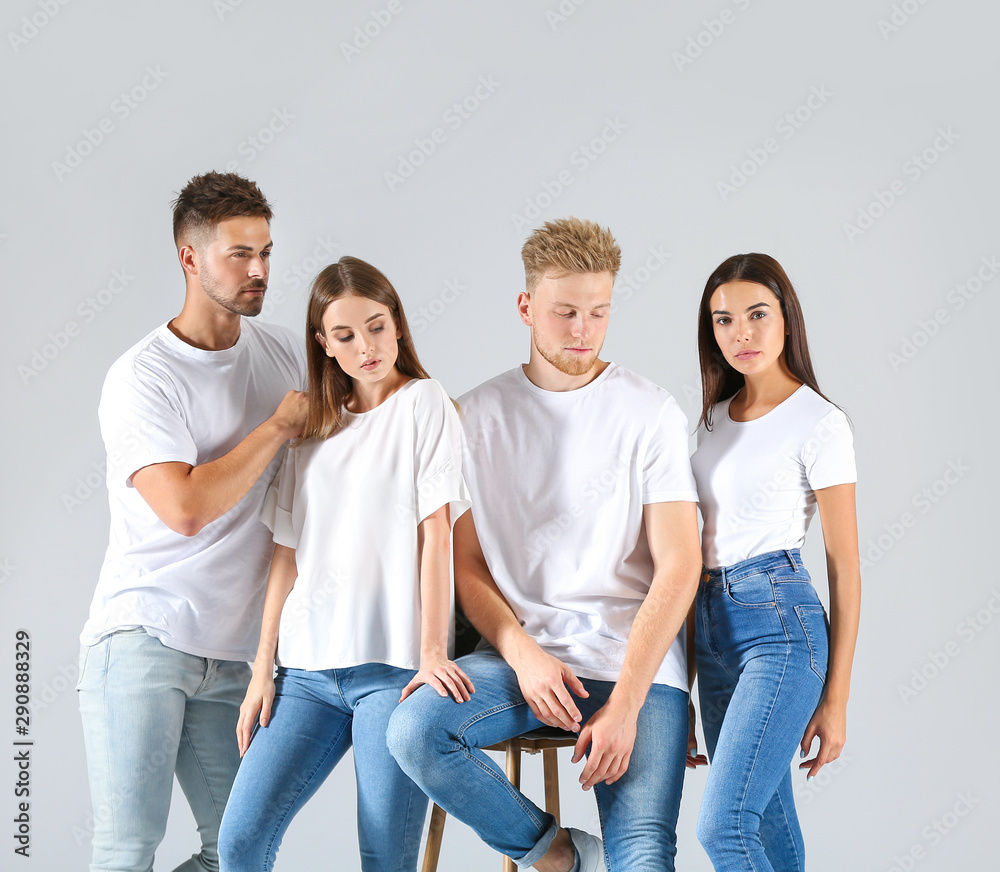 Group of young people in stylish casual clothes on light background