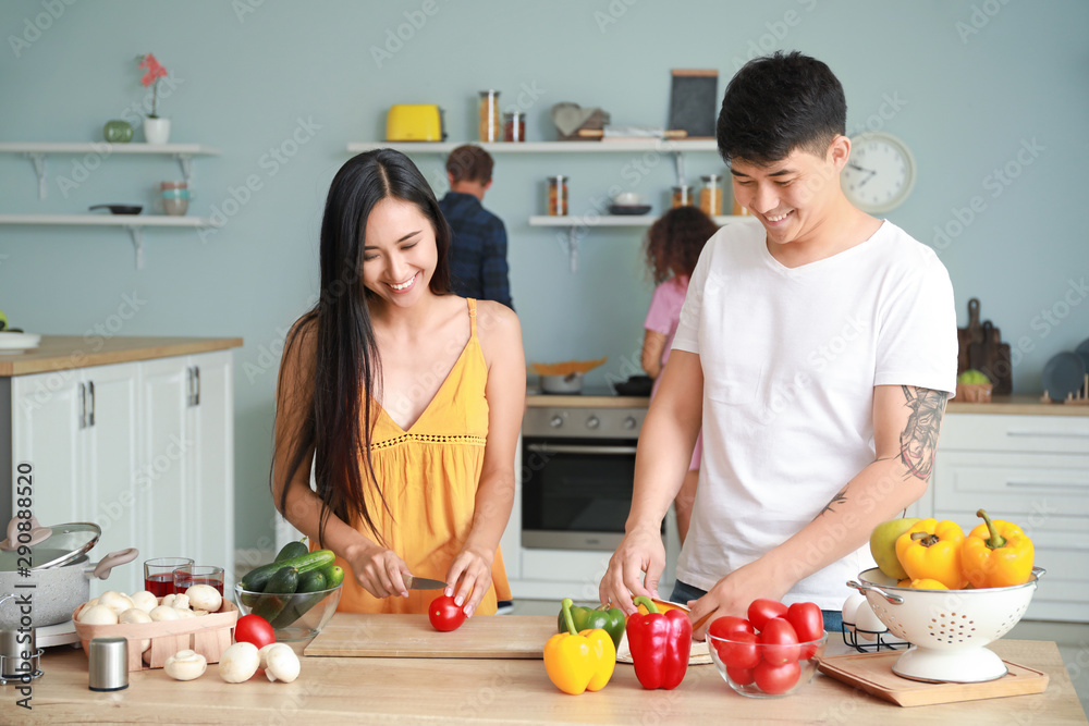 幸福的亚洲情侣在厨房一起做饭