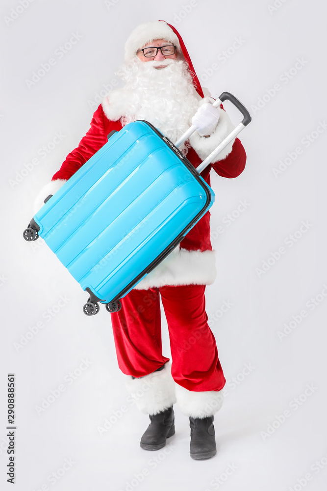 Santa Claus with luggage on white background