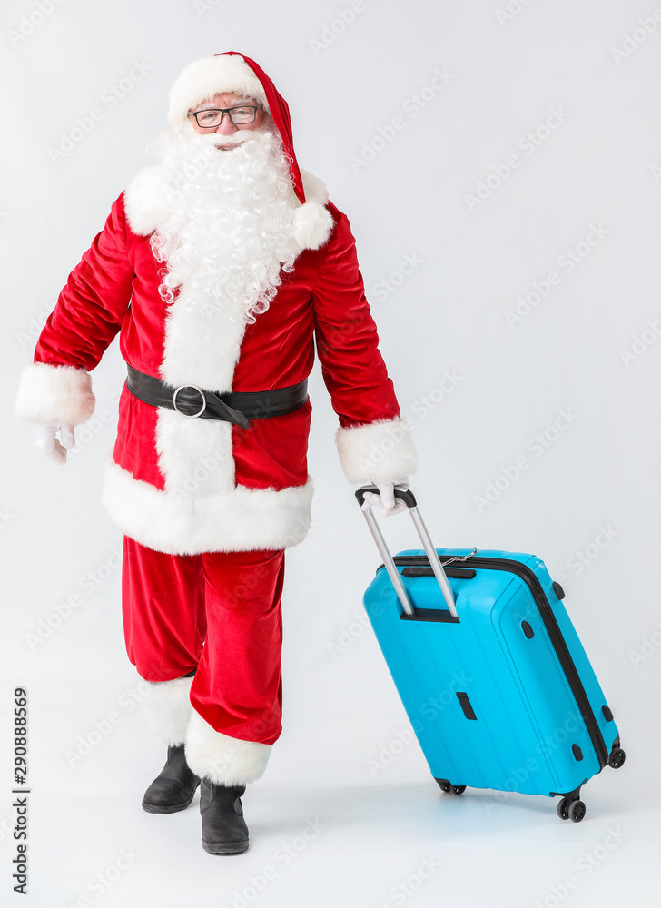 Santa Claus with luggage on white background