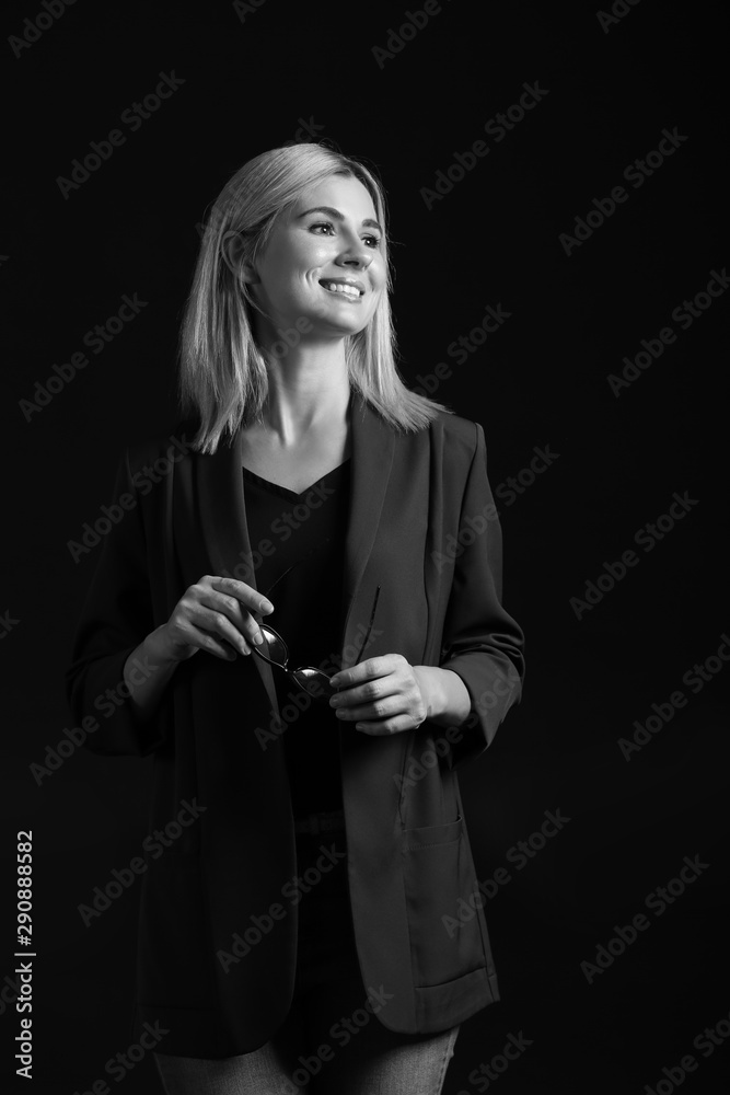 Black and white portrait of beautiful stylish businesswoman on dark background