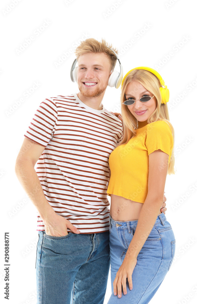 Young couple listening to music on white background