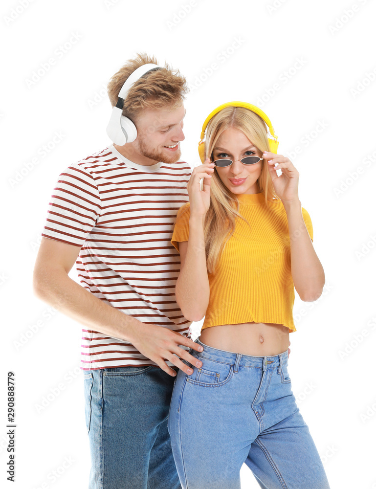 Young couple listening to music on white background