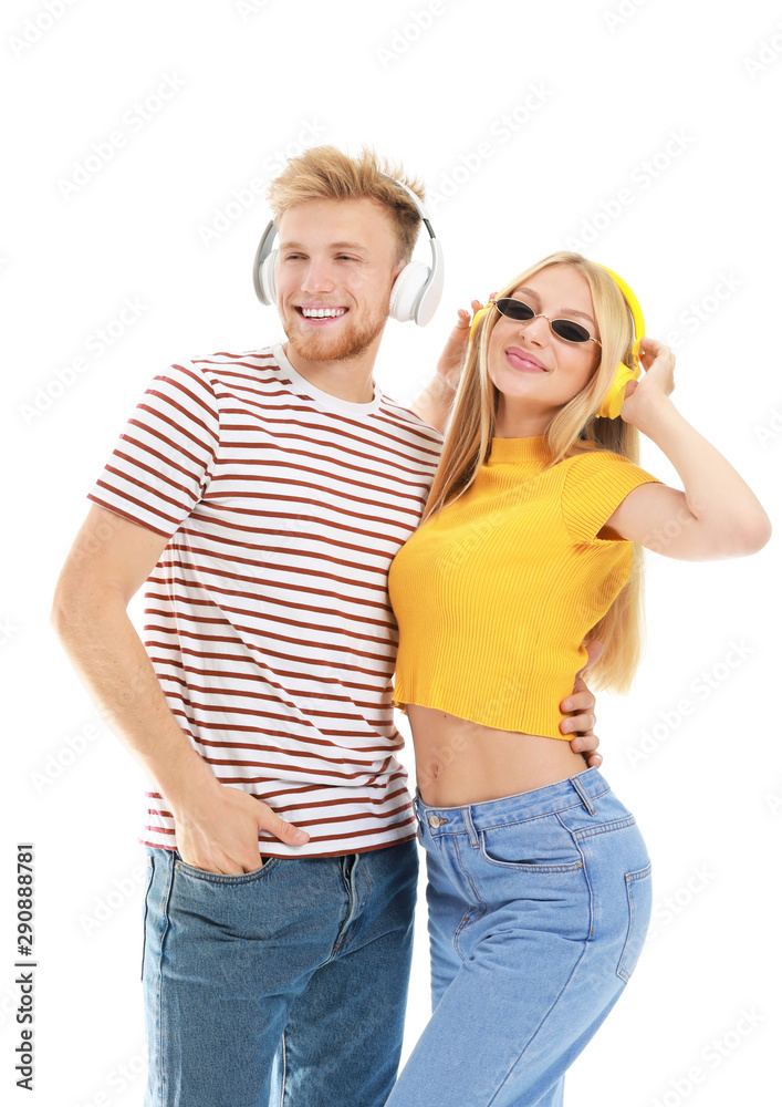 Young couple listening to music on white background