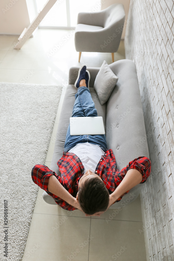 Man with laptop relaxing at home