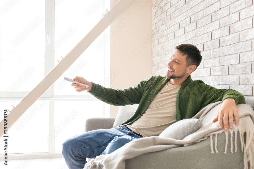 Happy man watching TV at home