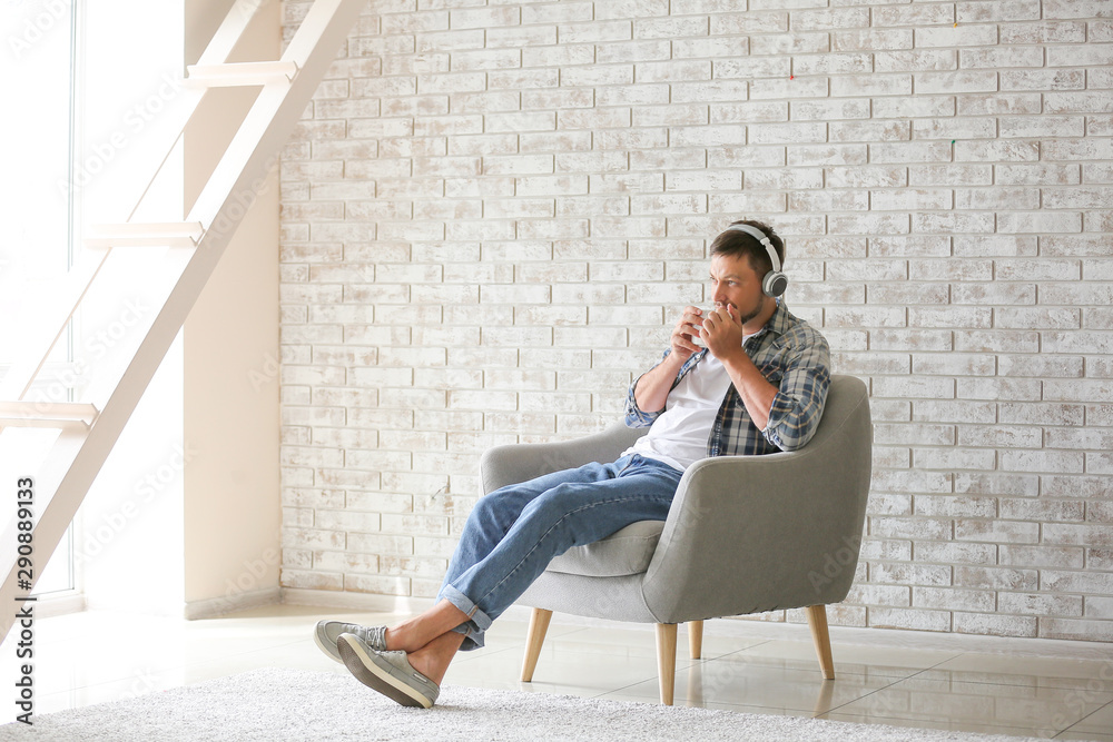 Man with headphones and cup of tea relaxing at home