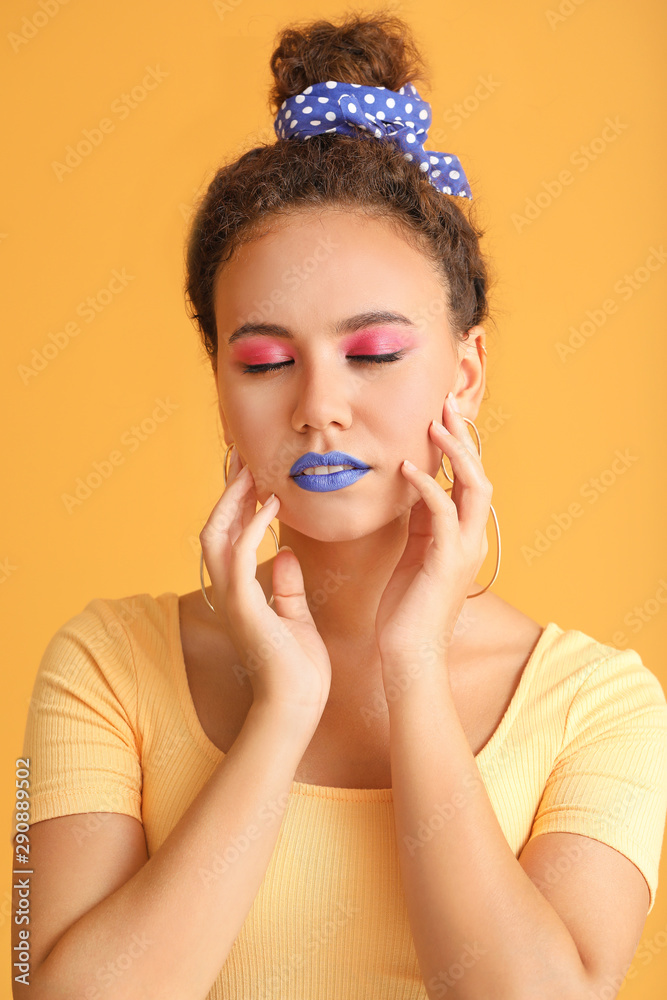 Portrait of fashionable young African-American woman on color background