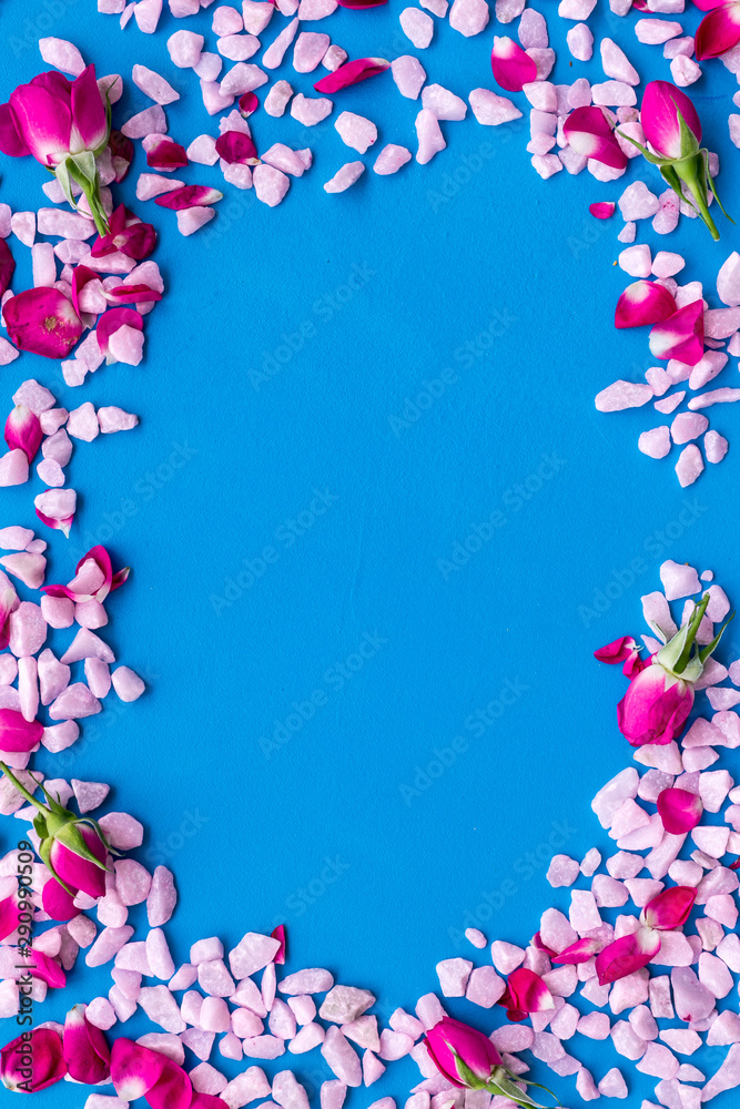 decorative pebble and roses frame for design on blue background top view mock-up