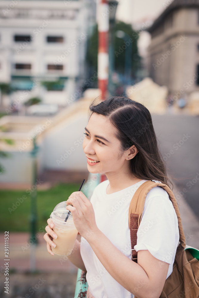 迷人时尚的可爱女孩在户外喝咖啡。