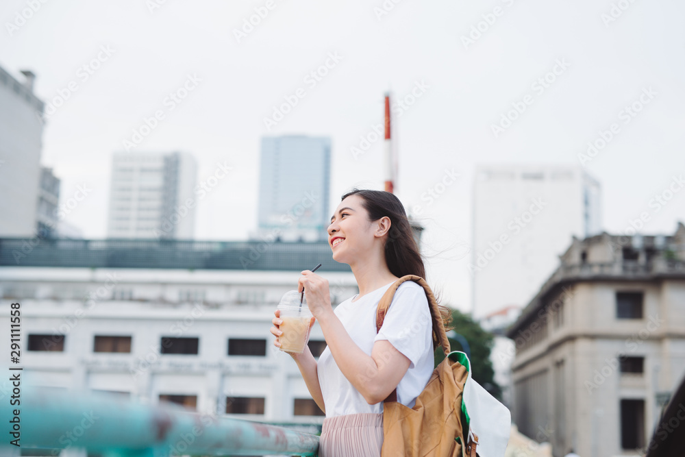 迷人时尚的可爱女孩在户外喝咖啡。