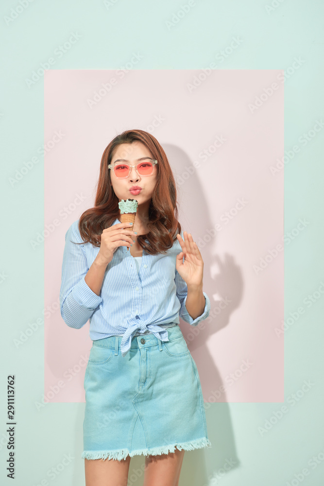 summer, junk food and people concept - young woman or teenage girl in sunglasses eating ice cream