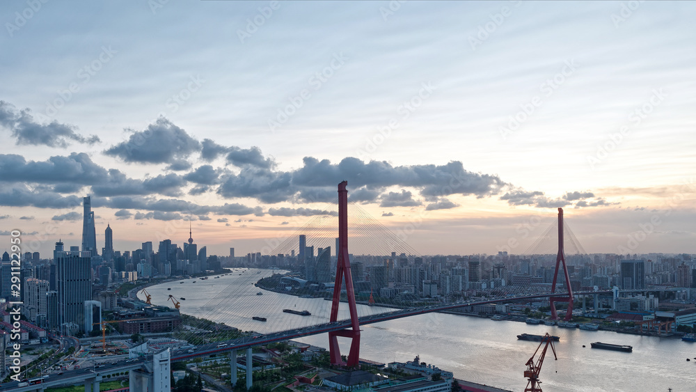 日落时的上海天际线。上海城市景观，黄浦江和杨浦大桥，多云的天空，泛