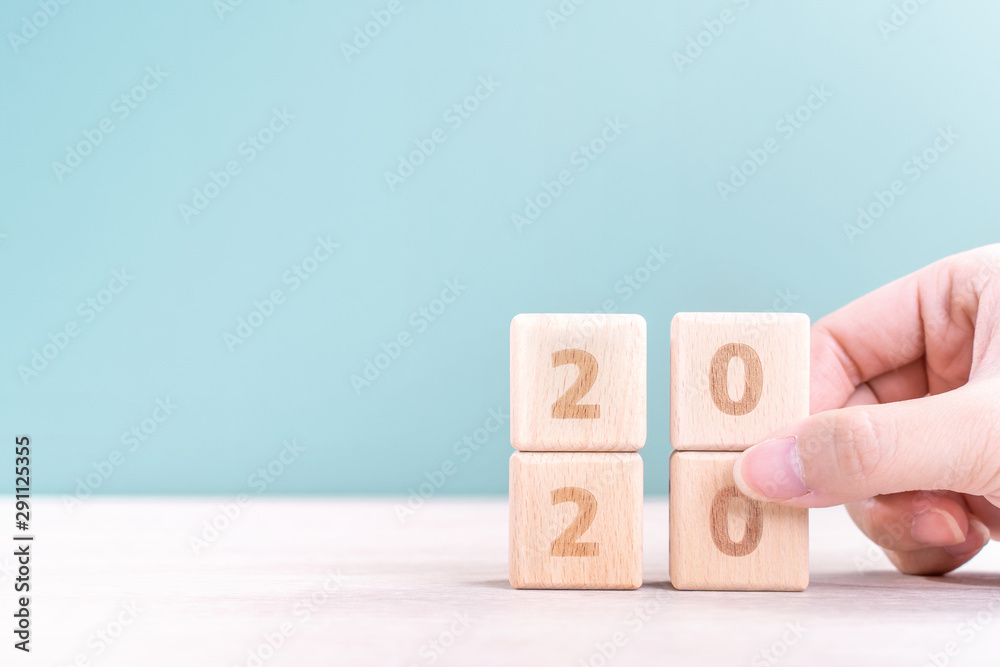 摘要2020和2019新年倒计时设计理念-妇女在木制t上拿着木块立方体