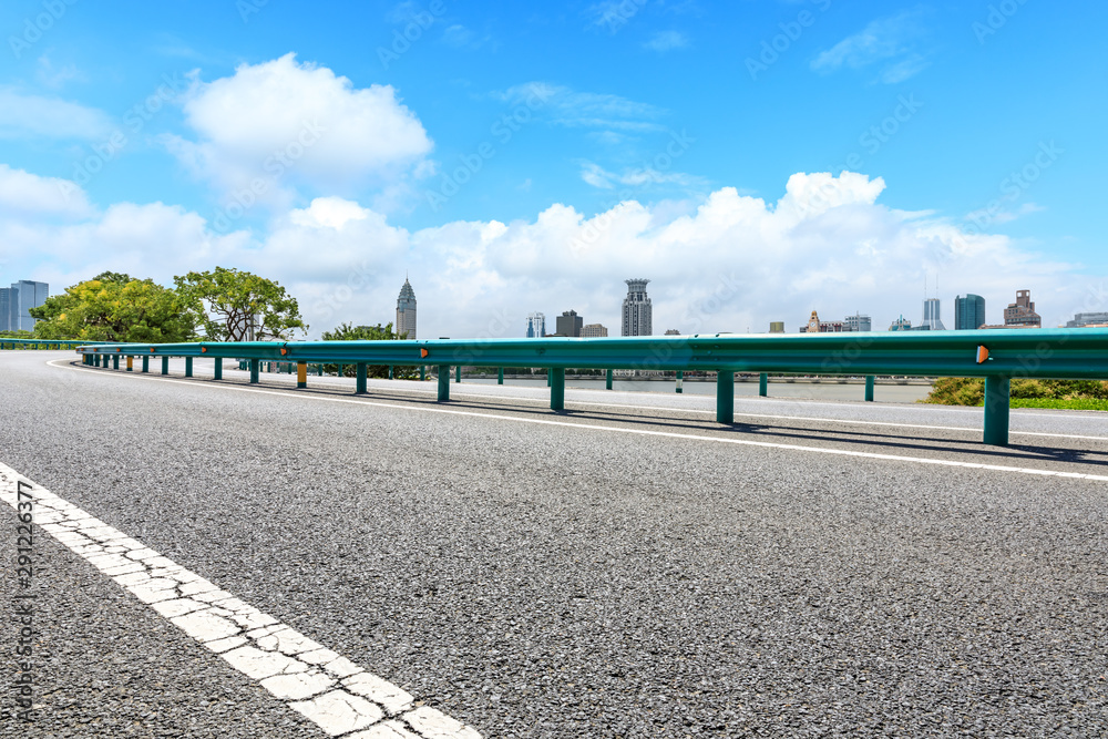 中国上海，空旷的柏油公路和城市天际线，建筑林立。