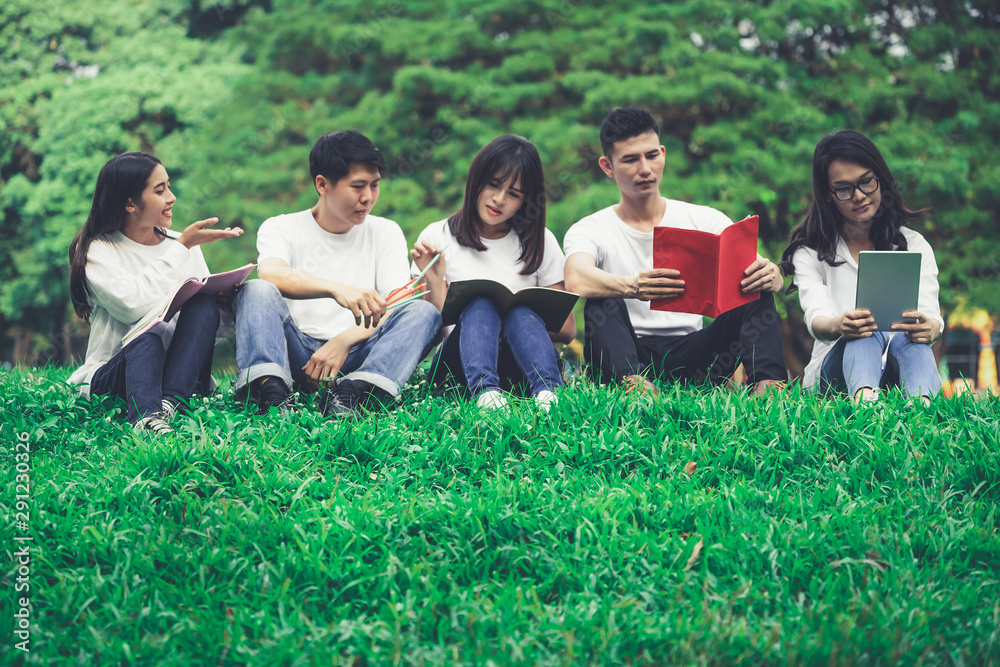 在大学或学校公园的小组项目中学习的年轻学生团队。快乐学习