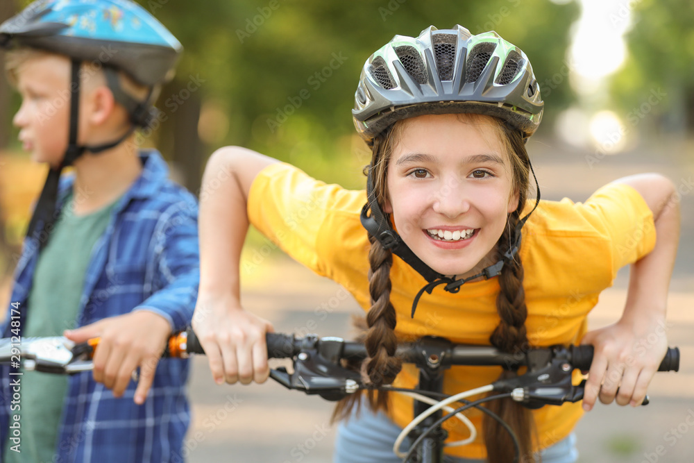 Cute children riding bicycles outdoors