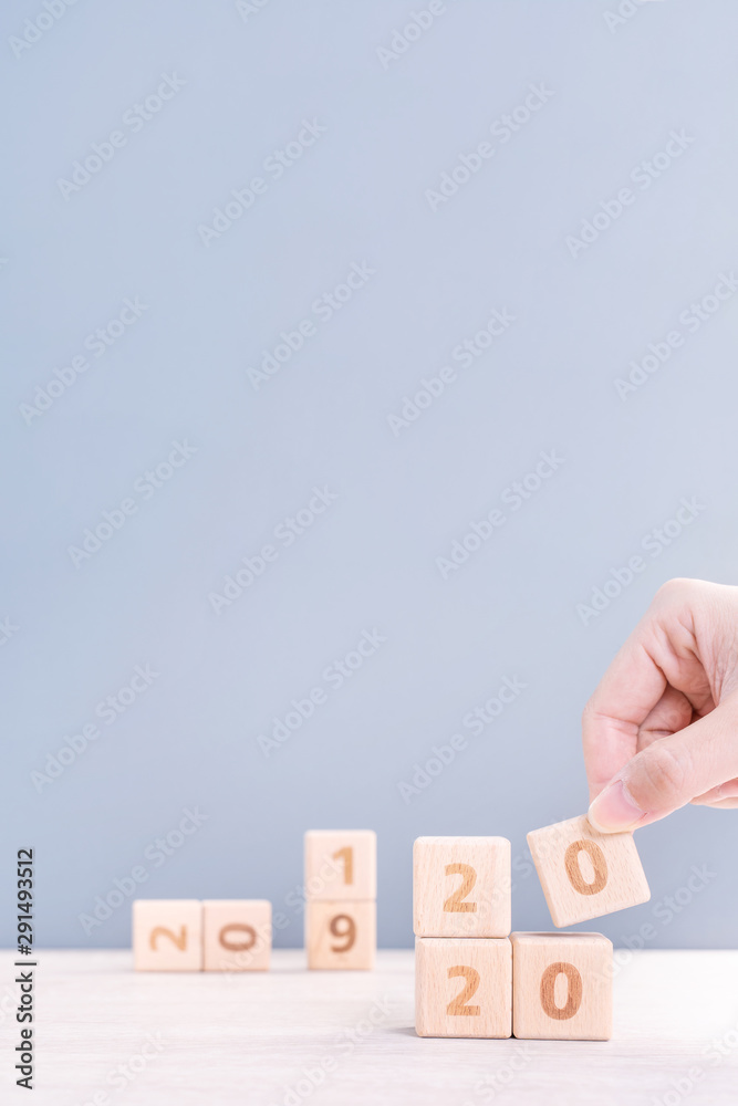 Abstract 2020 & 2019 New year countdown design concept - woman holding wood blocks cubes on wooden t