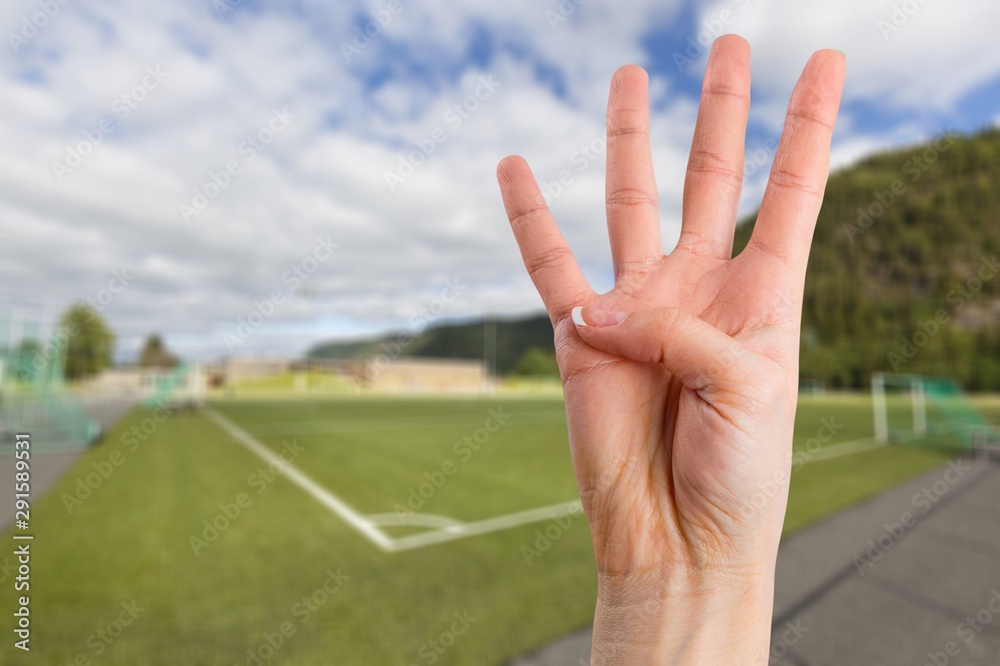 Young woman showing four fingers with hand on blue background