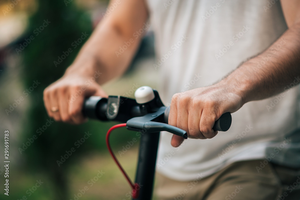 一名男子骑着电动踏板车的特写图片。