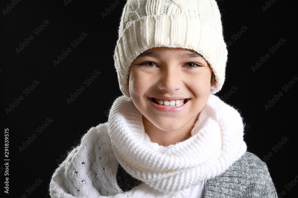 Happy little boy in warm clothes on dark background