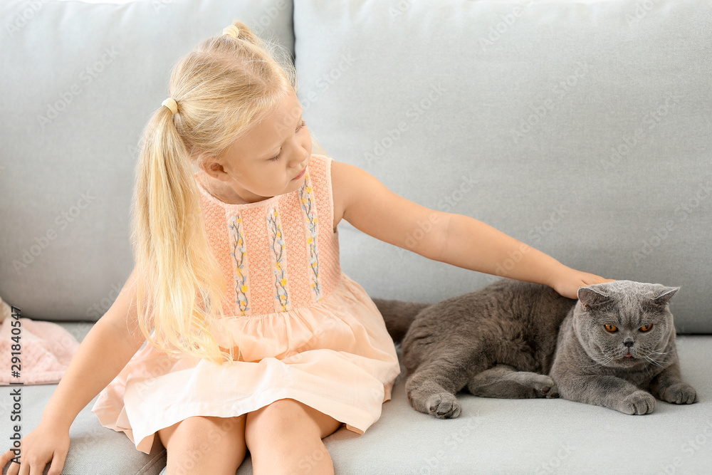 Little girl with cute cat at home